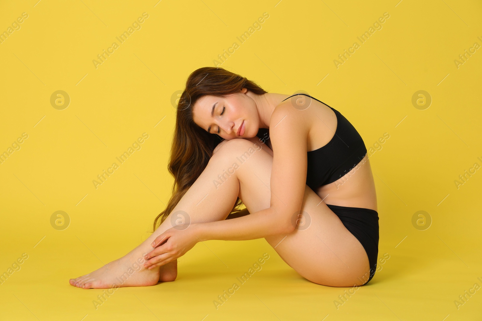 Photo of Woman with slim body posing on yellow background