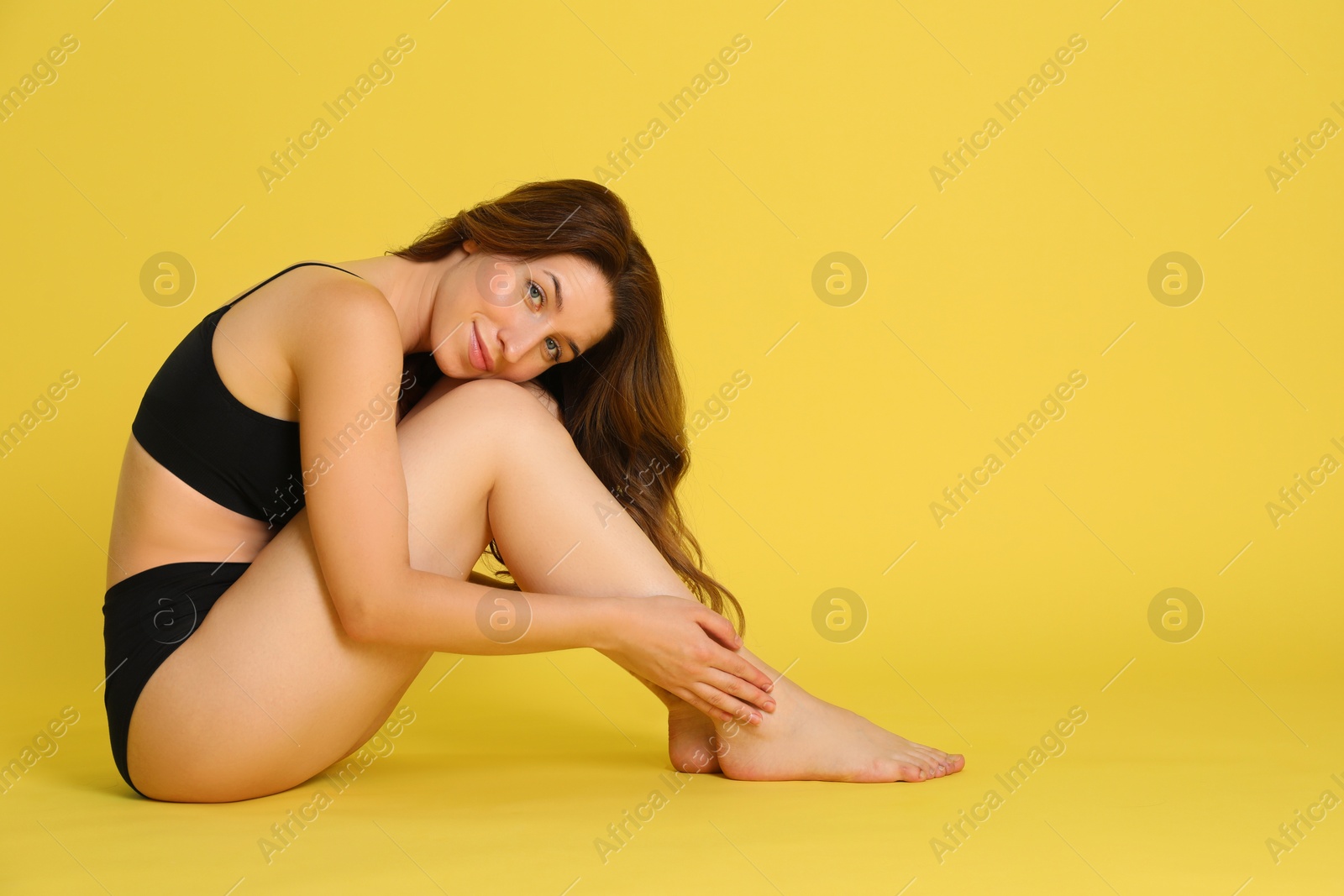 Photo of Woman with slim body posing on yellow background, space for text