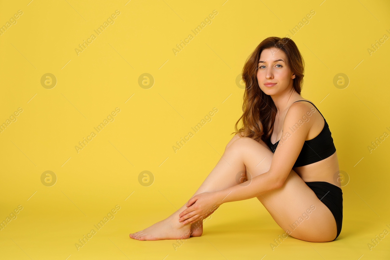 Photo of Woman with slim body posing on yellow background, space for text