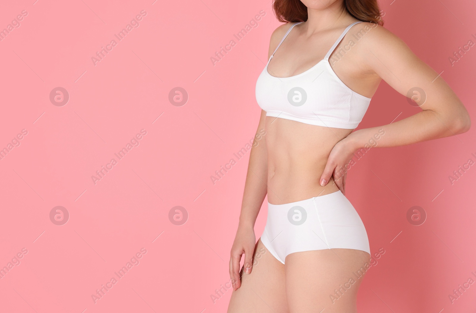 Photo of Woman with slim body posing on pink background, closeup. Space for text