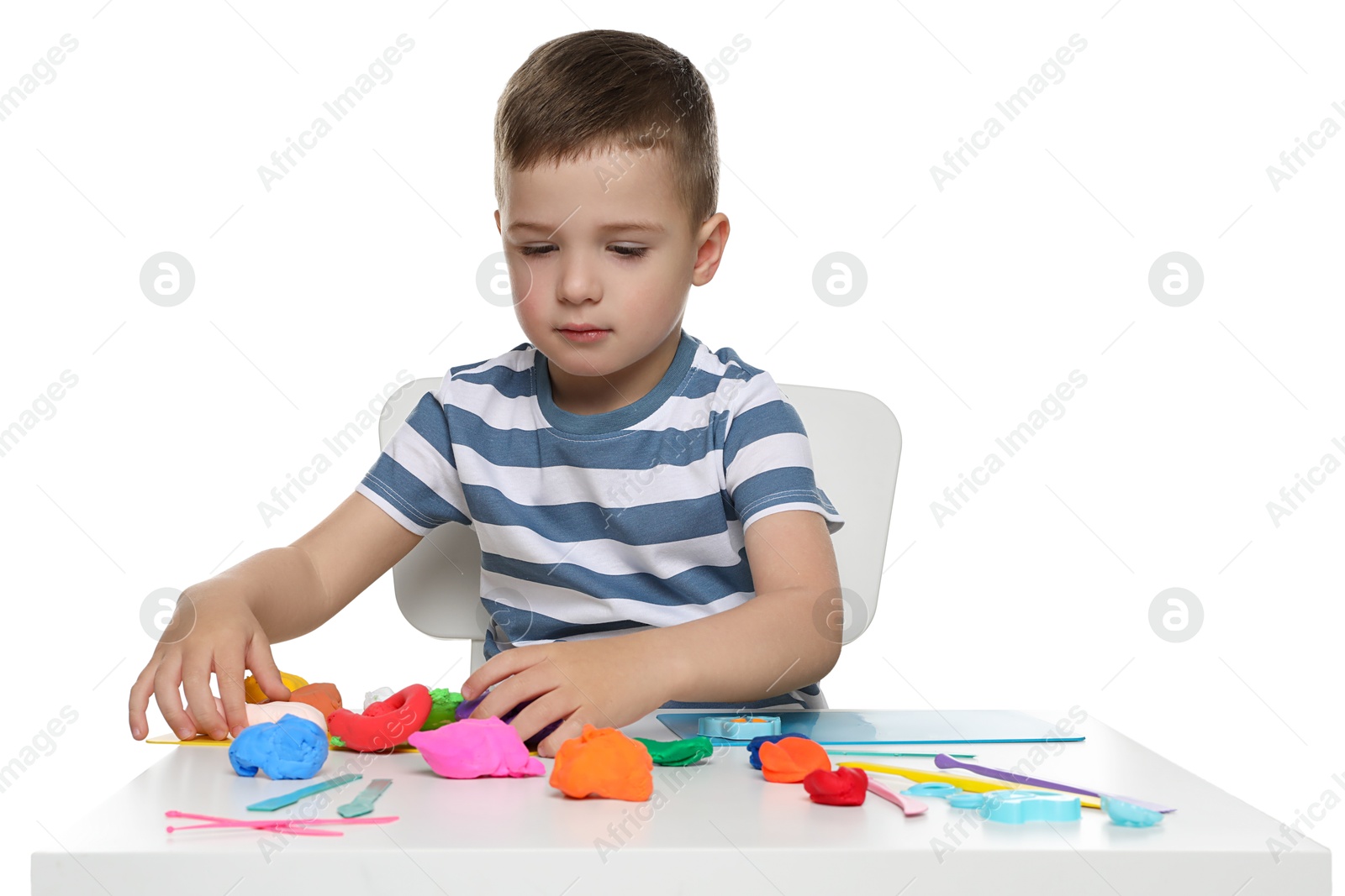 Photo of Little boy sculpting with play dough at table on white background