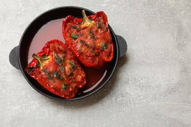 Photo of Tasty stuffed peppers in dish on light grey table, top view. Space for text