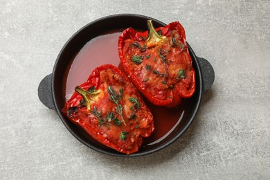 Photo of Tasty stuffed peppers in dish on light grey table, top view