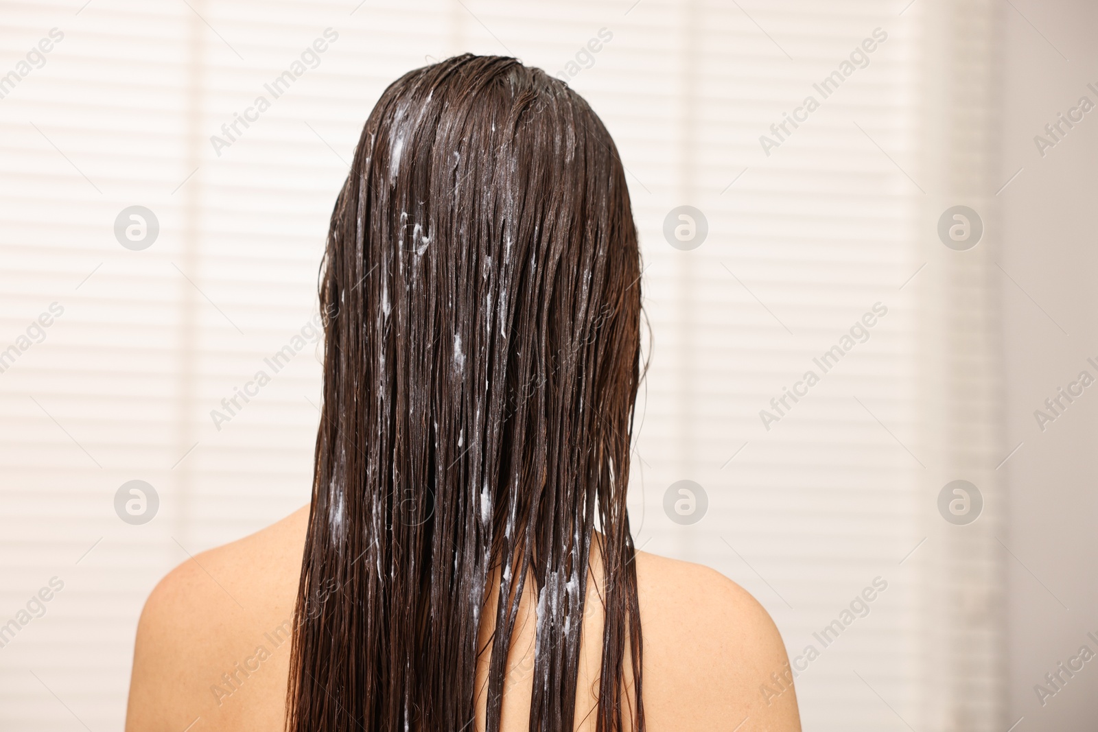 Photo of Woman with hair mask in bathroom, back view