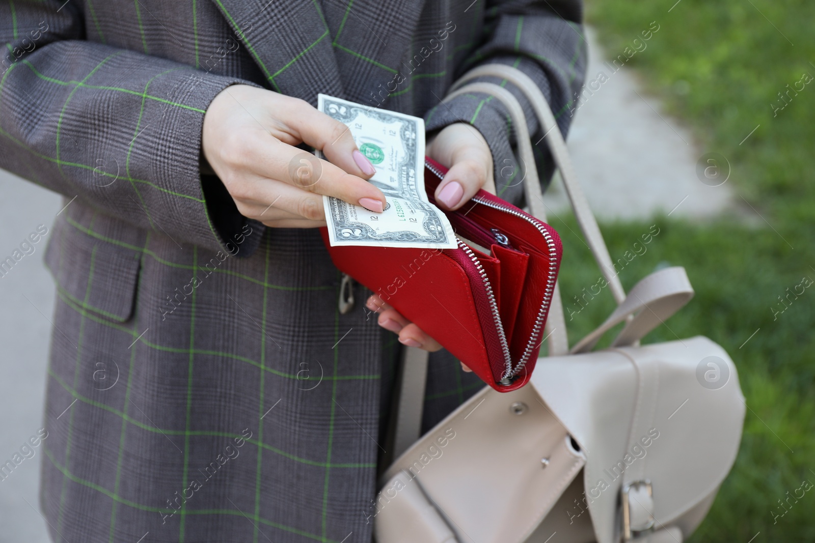 Photo of Woman holding purse with banknotes outdoors, closeup