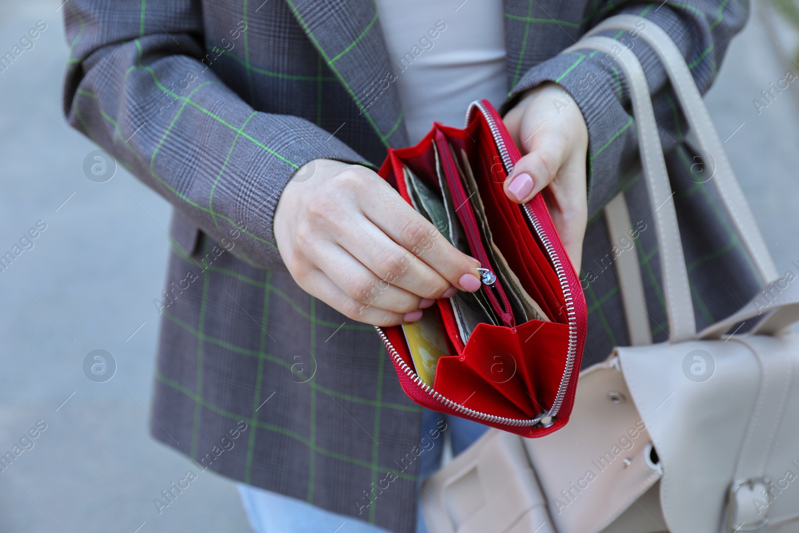 Photo of Woman holding purse with banknotes outdoors, closeup