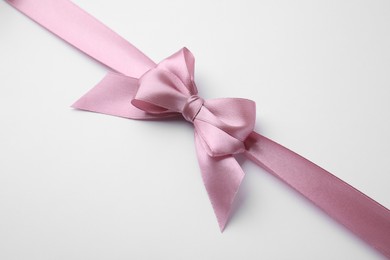 Pink satin ribbon with bow on white background