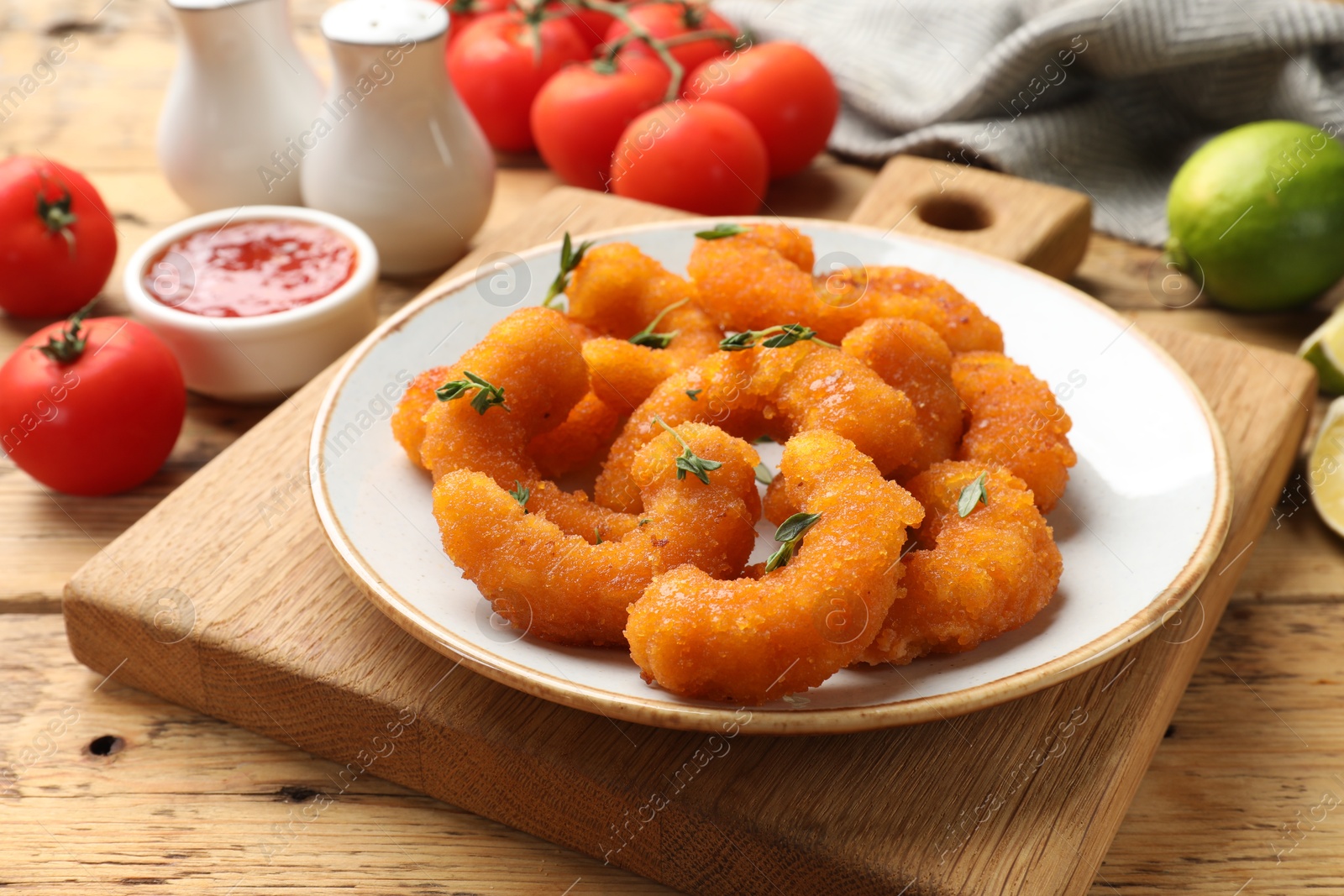 Photo of Tasty breaded fried shrimps served on wooden table, closeup