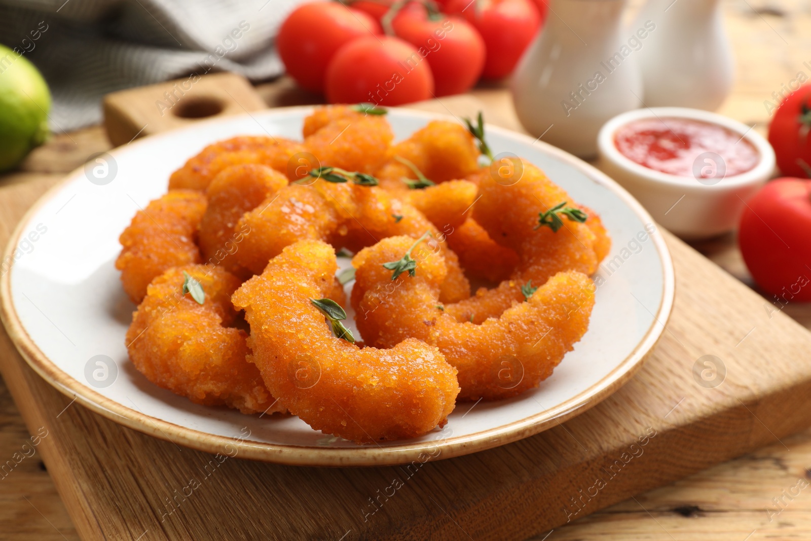 Photo of Tasty breaded fried shrimps served on wooden table, closeup