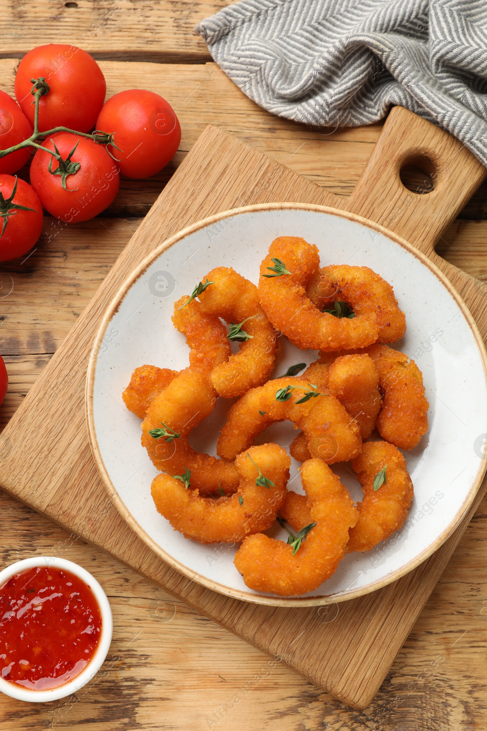 Photo of Tasty breaded fried shrimps served on wooden table, flat lay