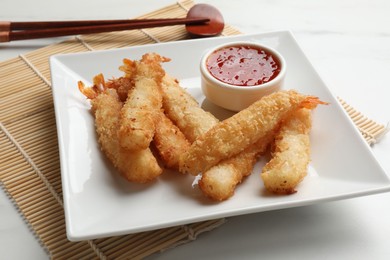 Tasty breaded fried shrimps served with sauce on white table, closeup