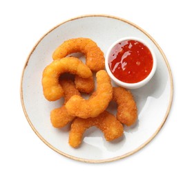 Tasty breaded fried shrimps and sauce isolated on white, top view