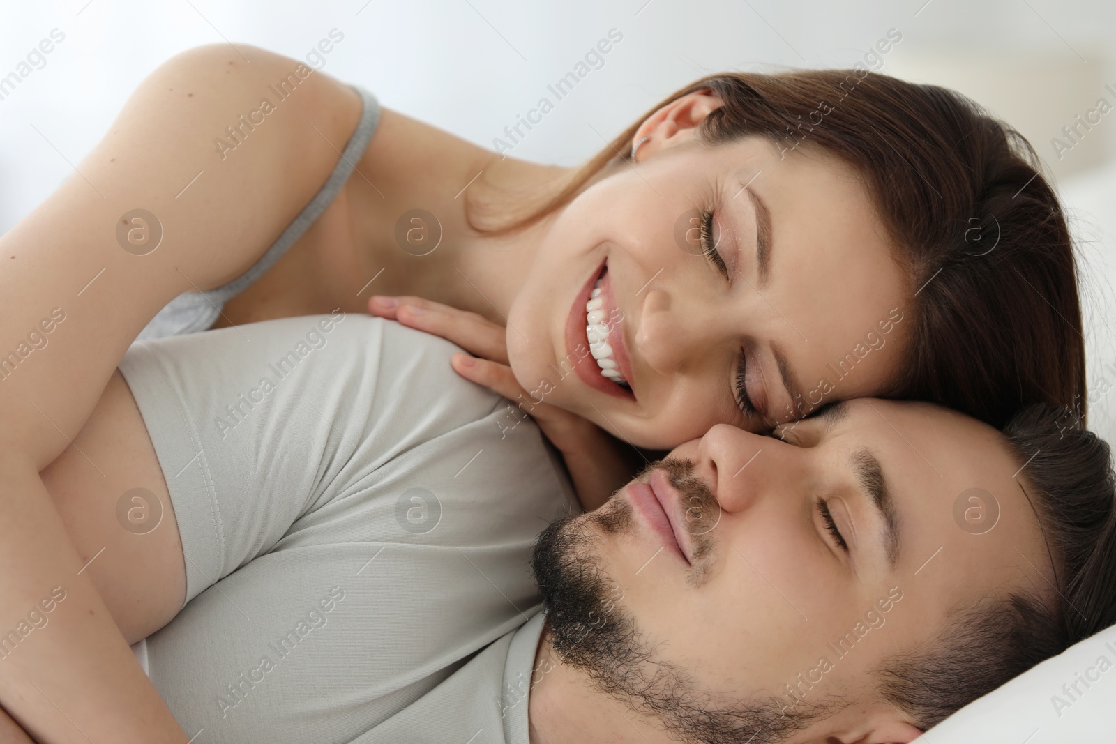 Photo of Lovely couple enjoying each other on bed at home