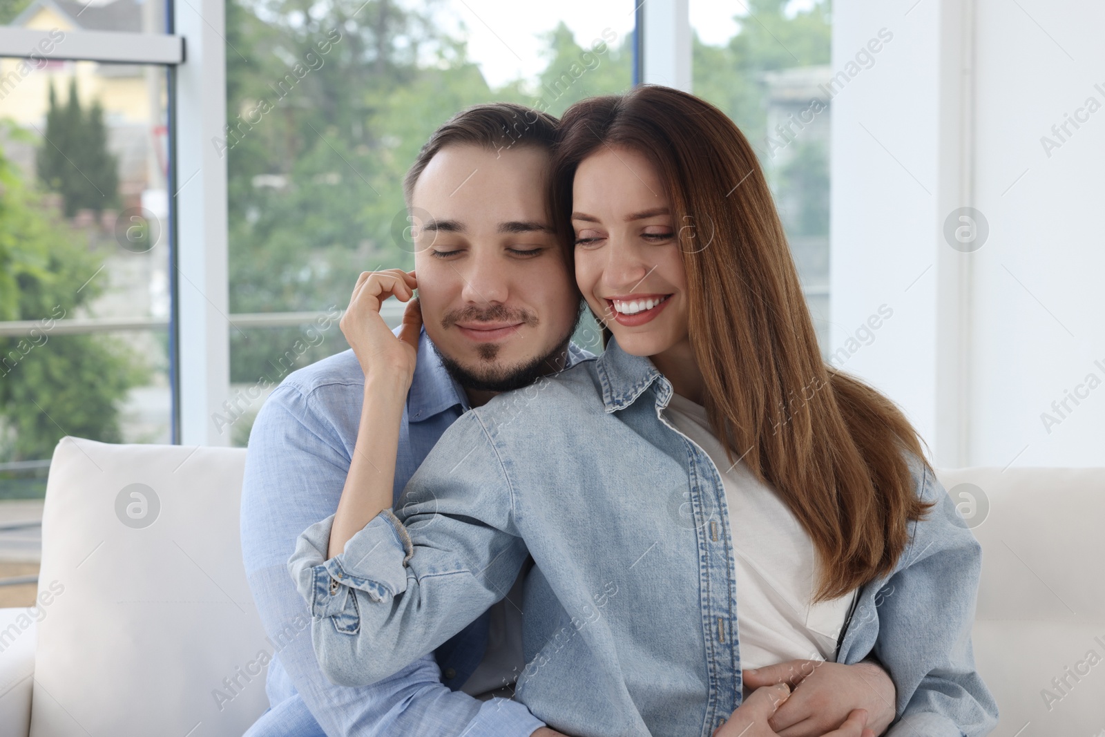 Photo of Man hugging his happy girlfriend at home