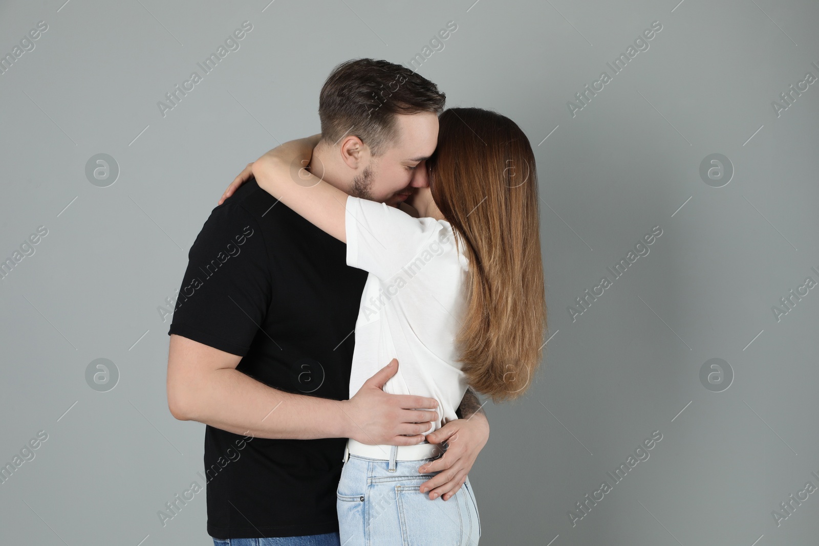 Photo of Lovely couple hugging on grey background. Strong relationship