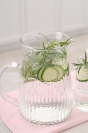 Photo of Refreshing cucumber water with rosemary on table in kitchen, closeup