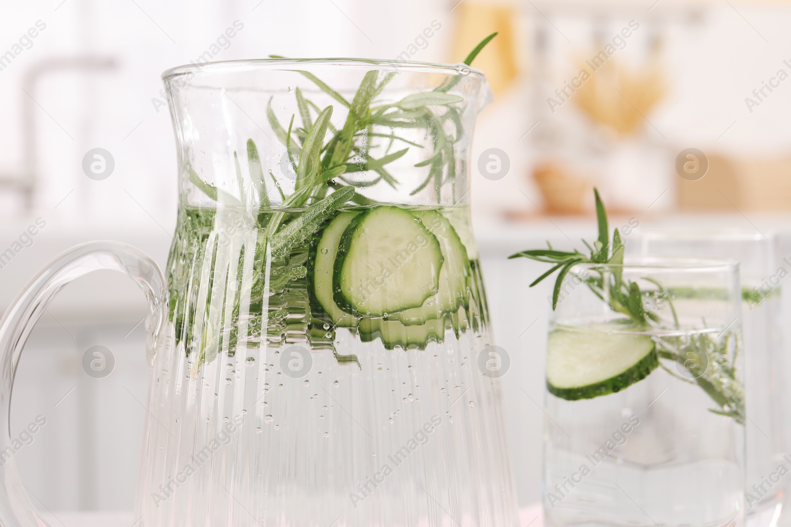 Photo of Refreshing cucumber water with rosemary on blurred background, closeup