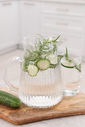 Refreshing cucumber water with rosemary and vegetable on table