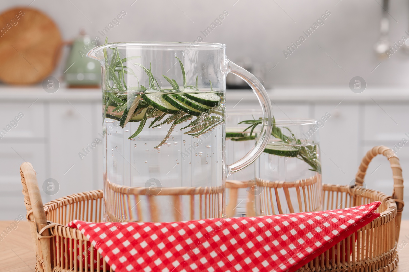 Photo of Refreshing cucumber water with rosemary on table, closeup