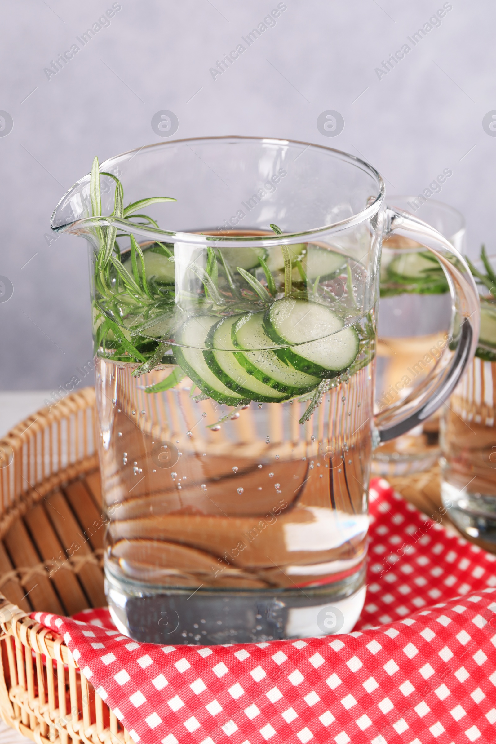 Photo of Refreshing cucumber water with rosemary in jug on table