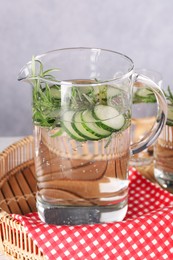 Photo of Refreshing cucumber water with rosemary in jug on table