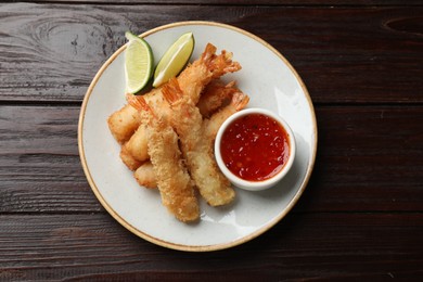 Photo of Delicious breaded fried shrimps served on wooden table, top view