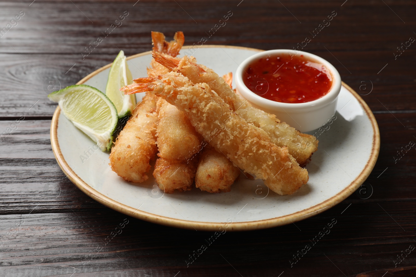 Photo of Delicious breaded fried shrimps served on wooden table