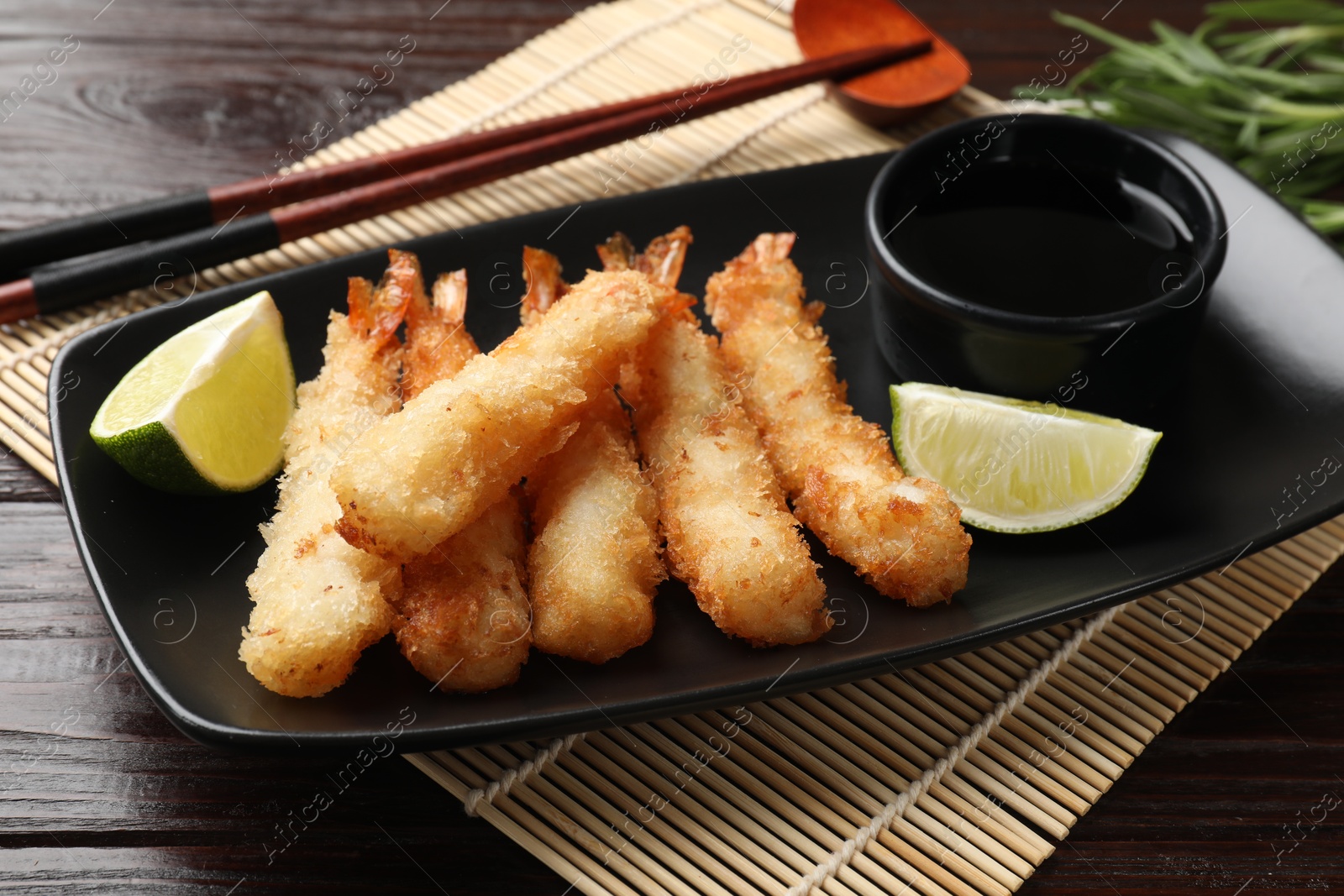 Photo of Delicious breaded fried shrimps served on wooden table