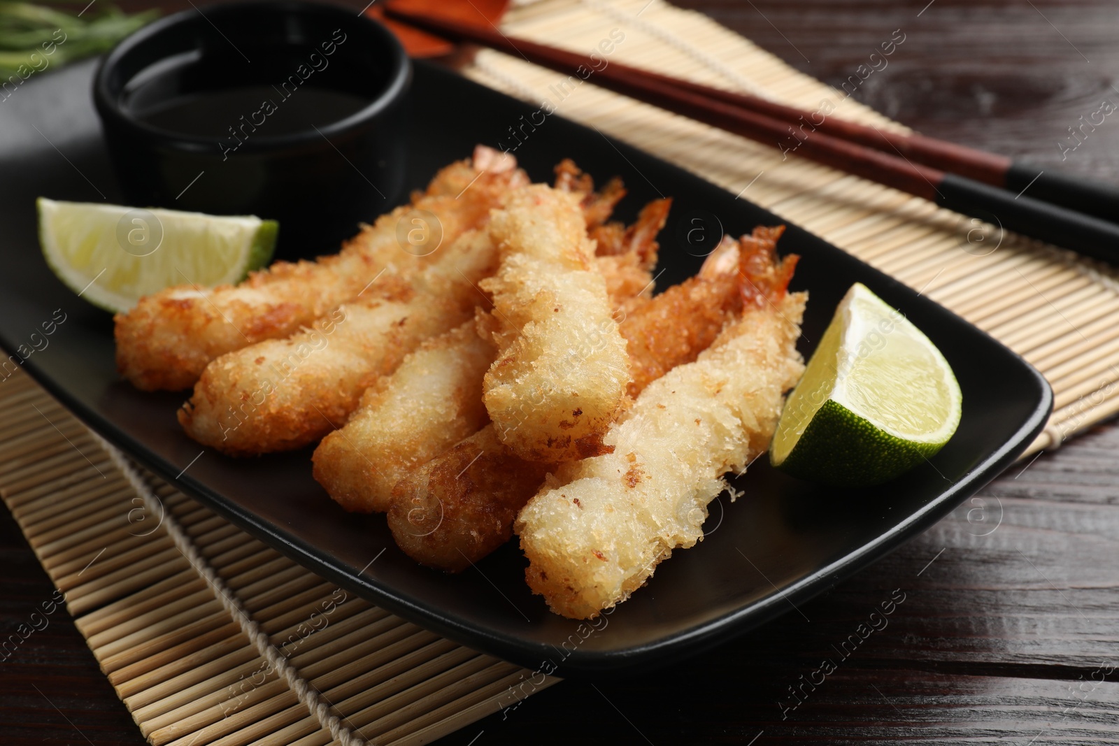 Photo of Delicious breaded fried shrimps served on wooden table, closeup