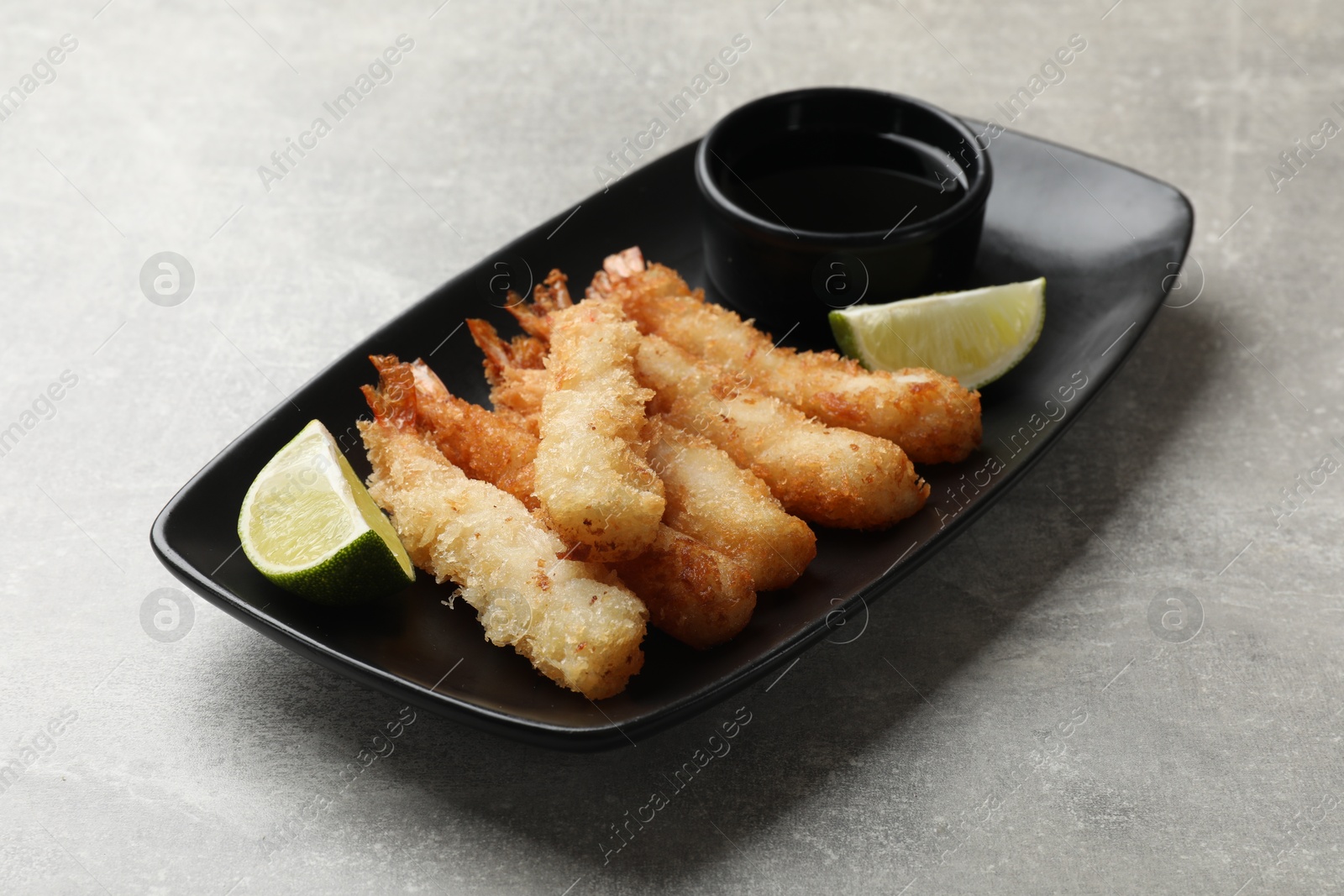 Photo of Delicious breaded fried shrimps served on grey table