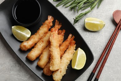 Photo of Delicious breaded fried shrimps served on grey table, flat lay