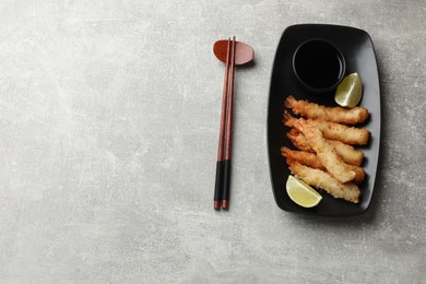 Delicious breaded fried shrimps served on grey table, flat lay. Space for text