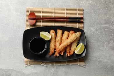 Delicious breaded fried shrimps served on grey table, top view