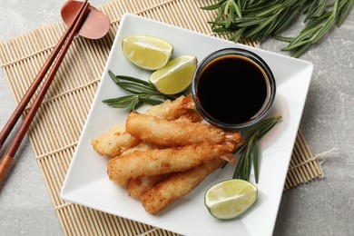 Photo of Delicious breaded fried shrimps served on grey table, flat lay