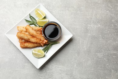 Photo of Delicious breaded fried shrimps served on grey table, top view. Space for text