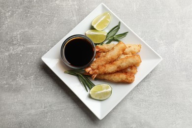 Photo of Delicious breaded fried shrimps served on grey table, top view