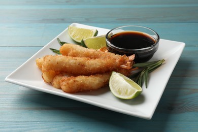 Delicious breaded fried shrimps served on light blue wooden table