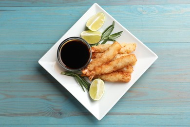 Delicious breaded fried shrimps served on light blue wooden table, top view