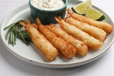 Delicious breaded fried shrimps served on white tiled table, closeup