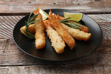 Delicious breaded fried shrimps served on wooden table