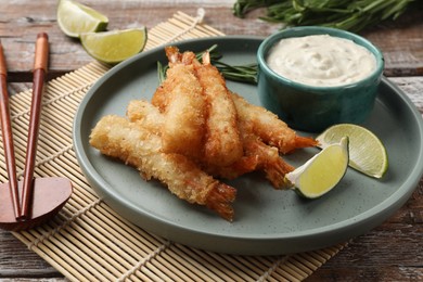 Photo of Delicious breaded fried shrimps served on wooden table