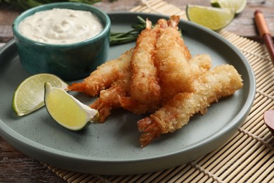 Delicious breaded fried shrimps served on wooden table, closeup