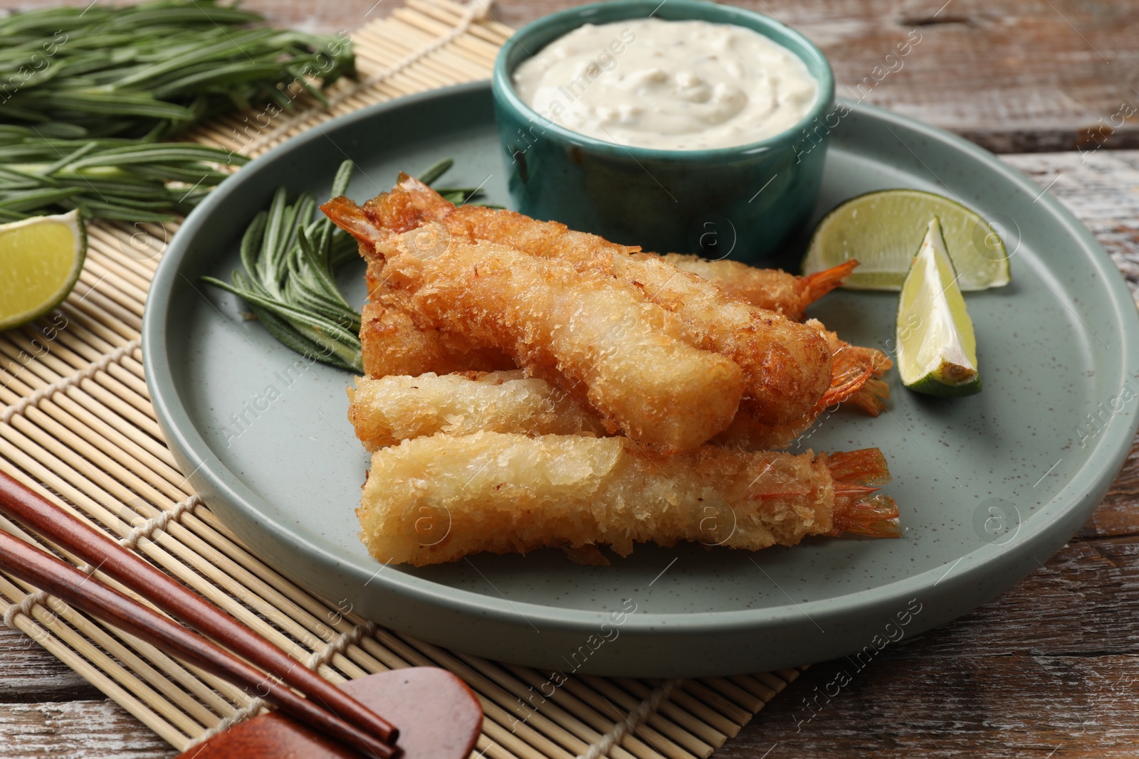 Photo of Delicious breaded fried shrimps served on wooden table