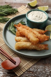 Photo of Delicious breaded fried shrimps served on wooden table