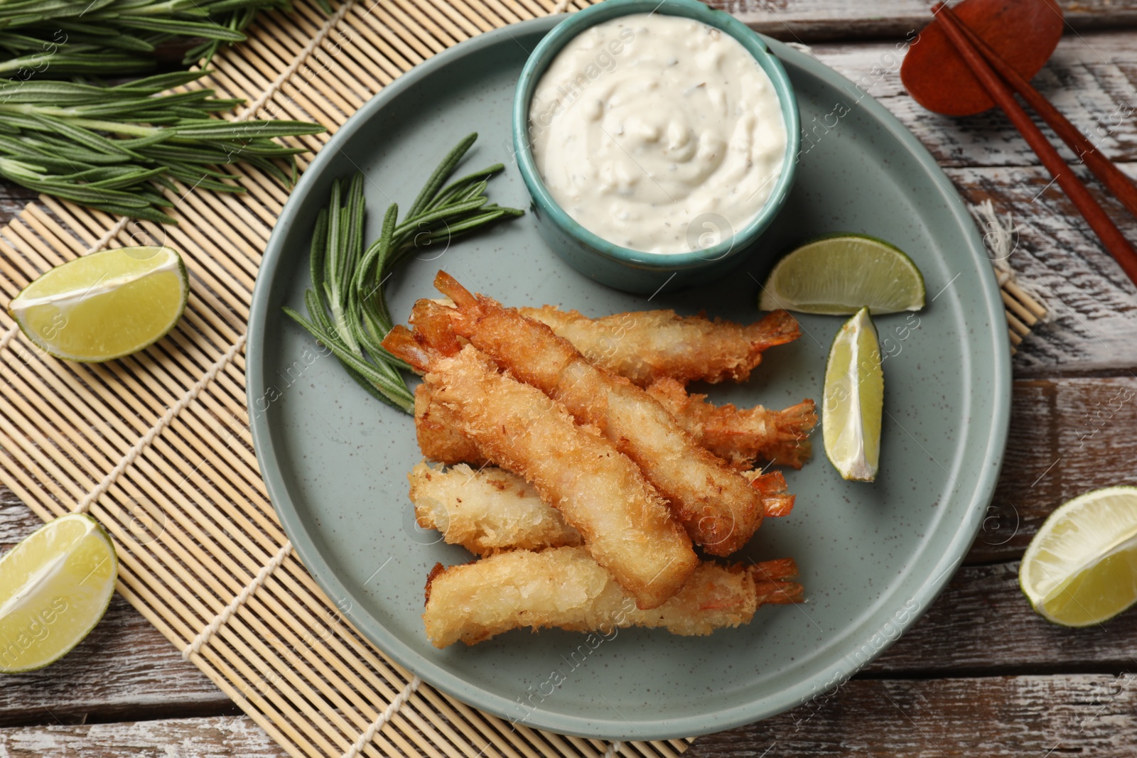 Photo of Delicious breaded fried shrimps served on wooden table, flat lay