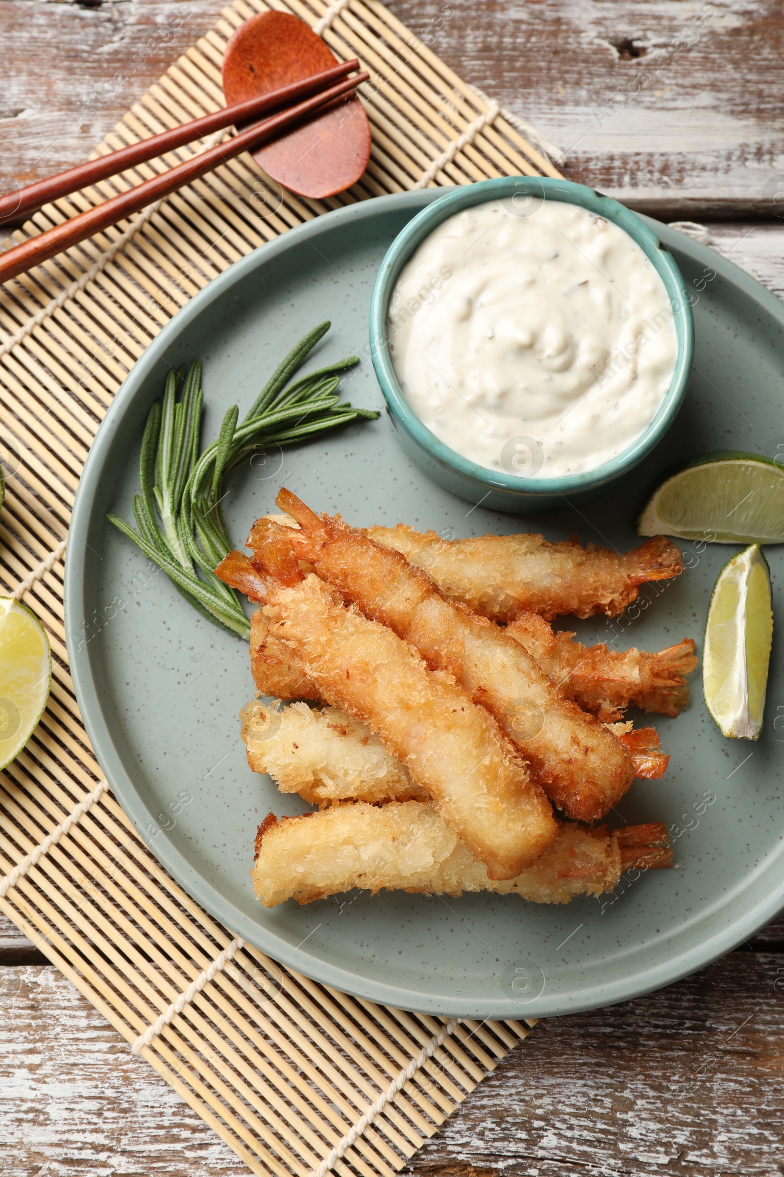 Photo of Delicious breaded fried shrimps served on wooden table, flat lay