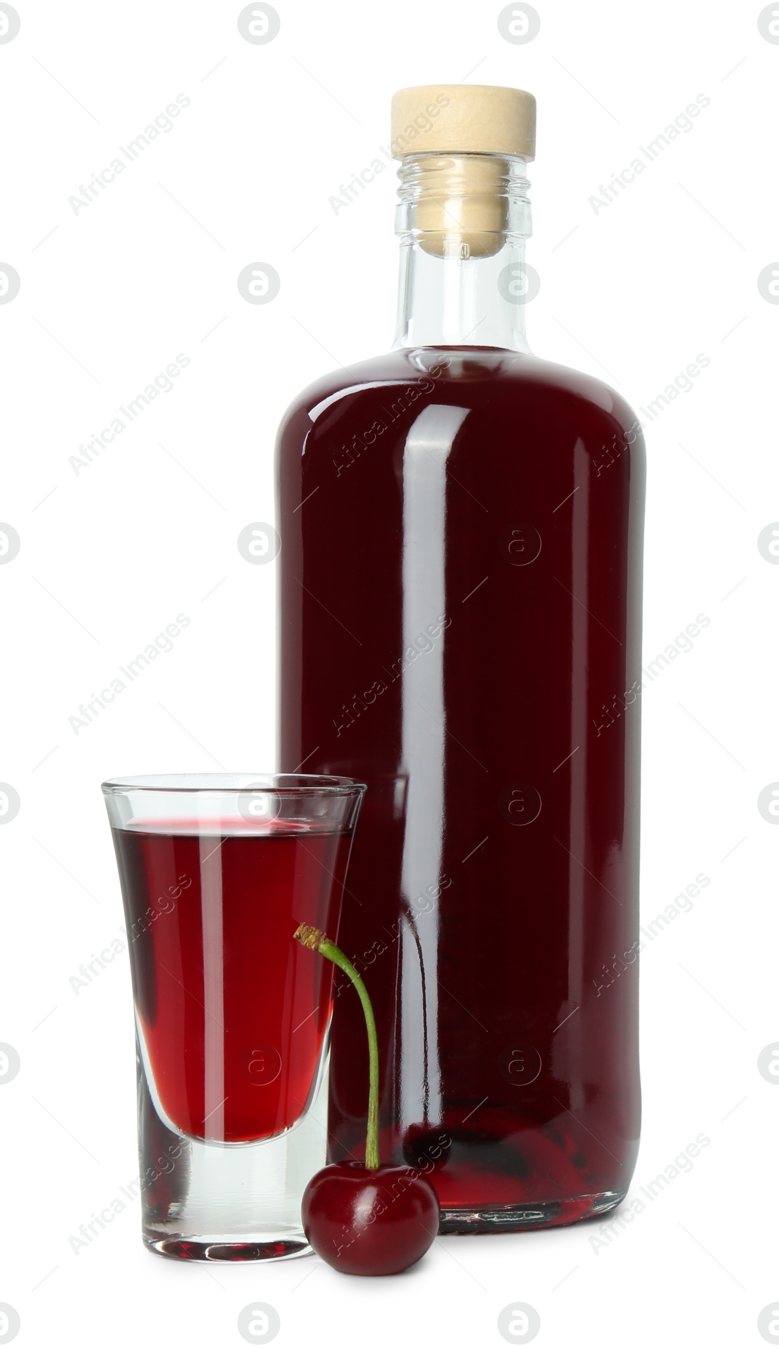 Photo of Bottle and shot glass of delicious cherry liqueur isolated on white