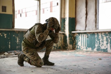 Photo of Military mission. Soldier in uniform inside abandoned building, space for text