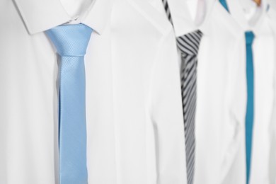 Photo of Three white shirts with neckties, closeup view