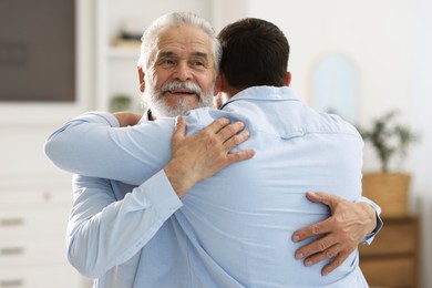 Happy dad and his son hugging at home